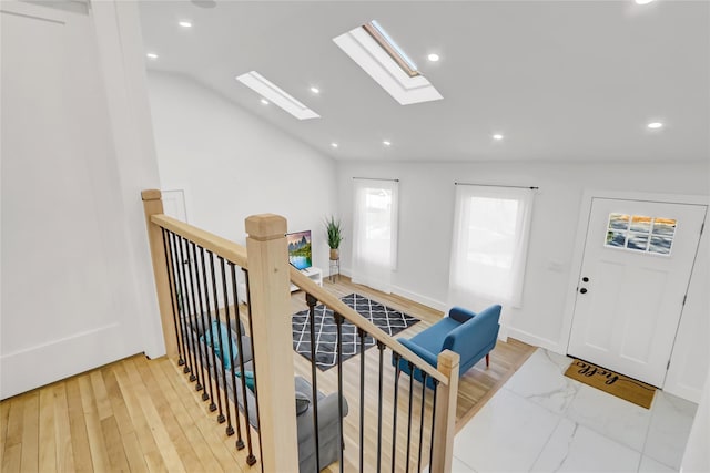 entryway featuring lofted ceiling with skylight, recessed lighting, and baseboards