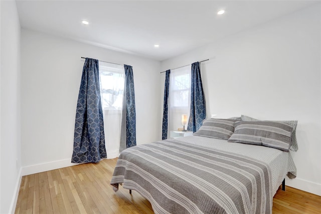 bedroom featuring baseboards, wood finished floors, and recessed lighting