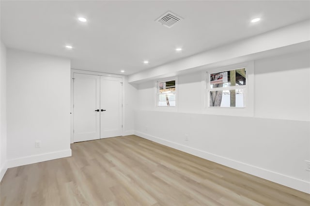 basement with light wood-type flooring, visible vents, baseboards, and recessed lighting