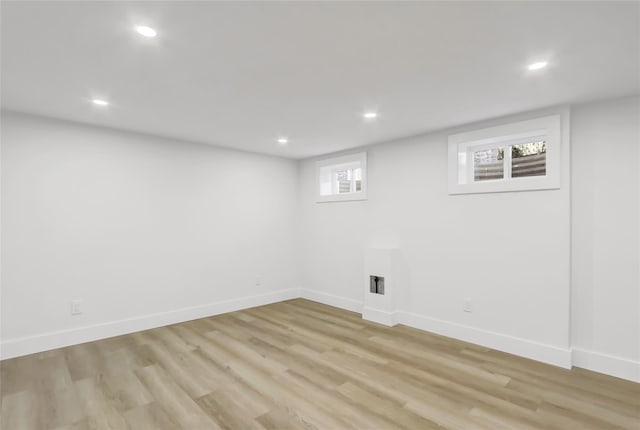 below grade area featuring light wood-style flooring, baseboards, and recessed lighting