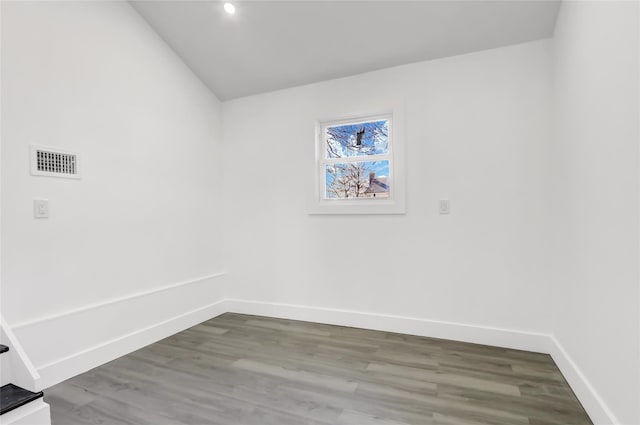 clothes washing area with baseboards, visible vents, and wood finished floors