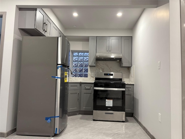 kitchen featuring stainless steel appliances, decorative backsplash, and gray cabinetry