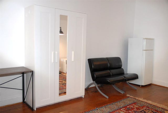 sitting room with dark wood-type flooring