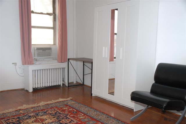 sitting room featuring radiator, cooling unit, and dark hardwood / wood-style floors