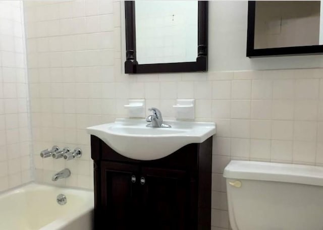 full bathroom with vanity, toilet, and tiled shower / bath combo