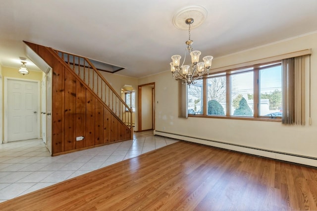 tiled spare room featuring a chandelier and a baseboard heating unit