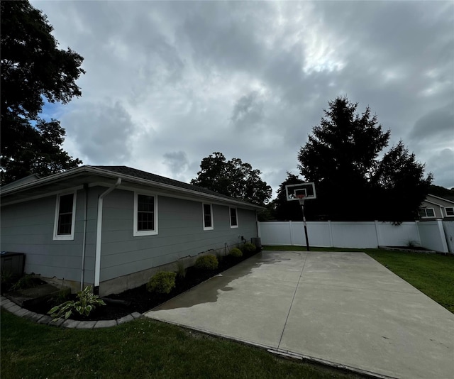 view of side of home with a lawn and a patio