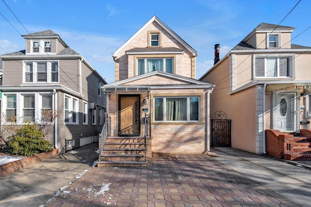 traditional style home featuring brick siding and a gate