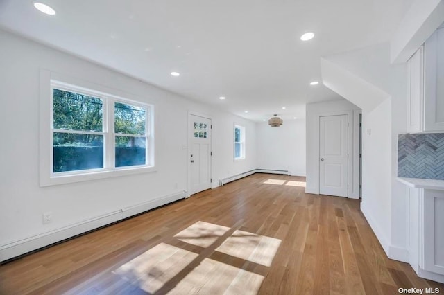 bonus room with a baseboard radiator and light hardwood / wood-style floors