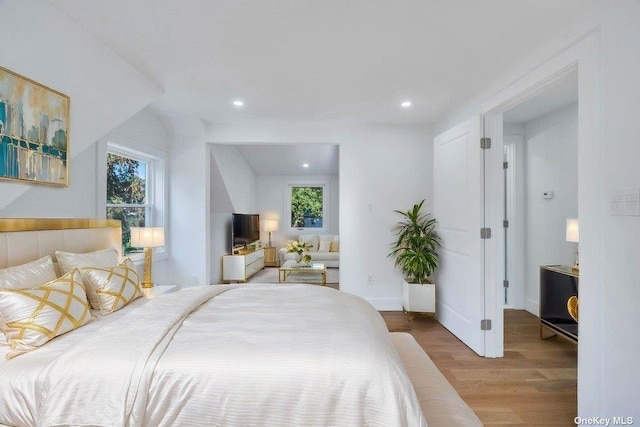 bedroom with multiple windows and light wood-type flooring