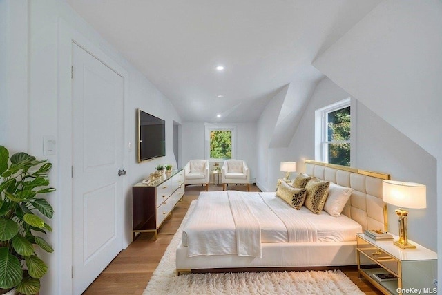 bedroom featuring lofted ceiling and light wood-type flooring