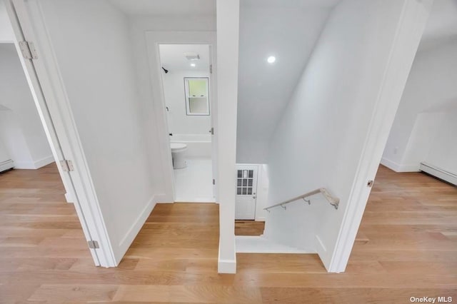 hallway with light wood-type flooring and baseboard heating