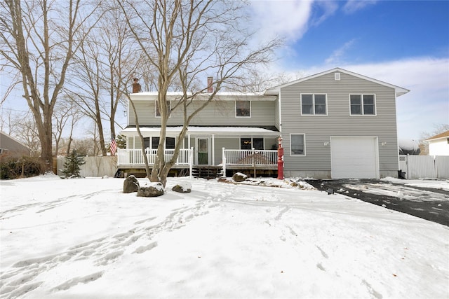 snow covered property featuring a garage and a porch