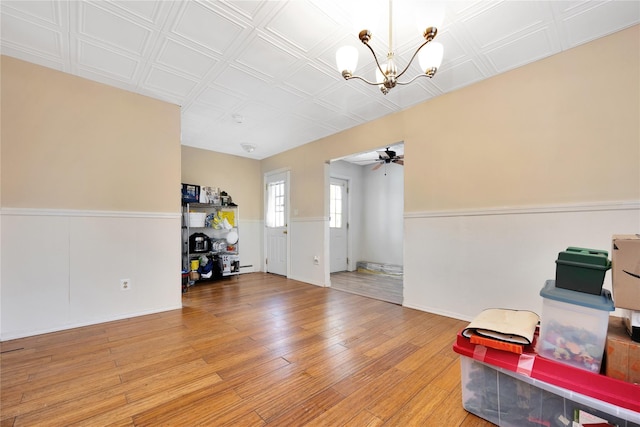 interior space featuring hardwood / wood-style flooring and ceiling fan with notable chandelier