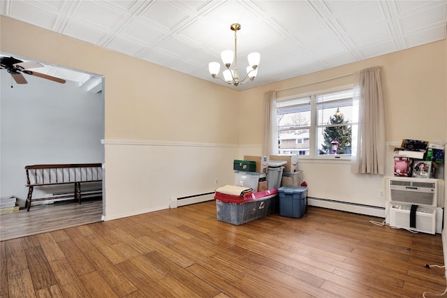 interior space with ceiling fan with notable chandelier, a baseboard radiator, and hardwood / wood-style floors