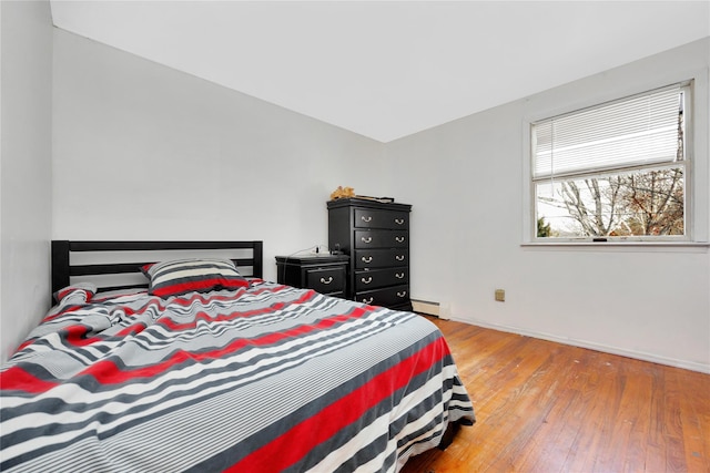 bedroom with light hardwood / wood-style flooring and baseboard heating