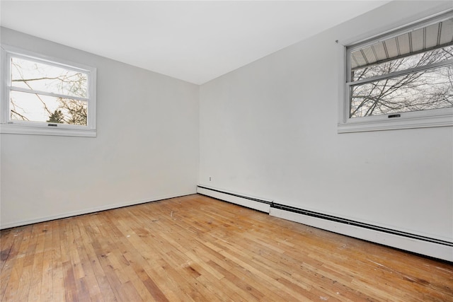 empty room with light wood-type flooring and baseboard heating