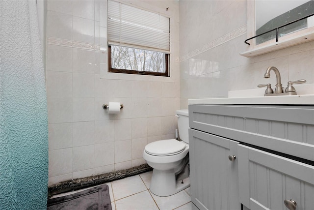 bathroom featuring tile patterned flooring, vanity, tile walls, and toilet