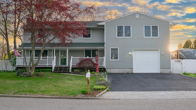 4 Young Rd, Coram, NY 11727 - view of front facade featuring driveway, an attached garage, fence, a porch, and a front lawn