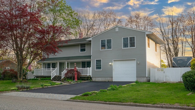 4 Young Rd, Coram, NY 11727 - view of front of property featuring driveway, fence, a porch, a front lawn, and a garage