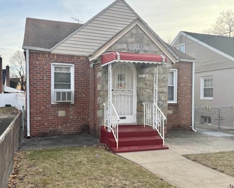 view of front of property with brick siding and fence