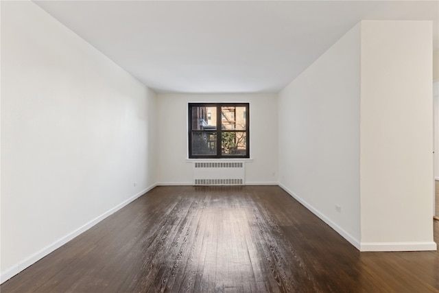 unfurnished room featuring radiator and dark wood-type flooring