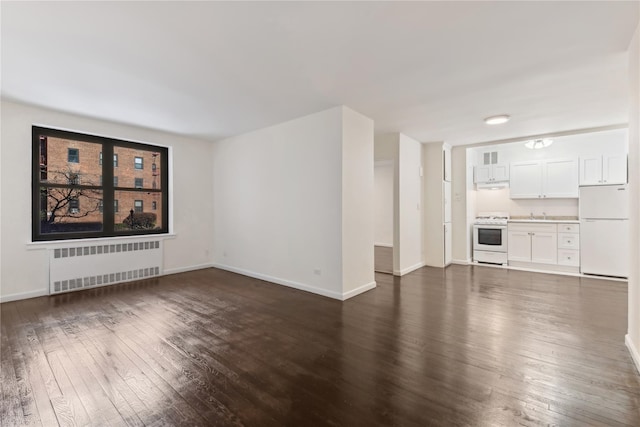 unfurnished living room featuring dark hardwood / wood-style floors and radiator