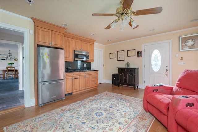 living room featuring light wood finished floors, a ceiling fan, and crown molding