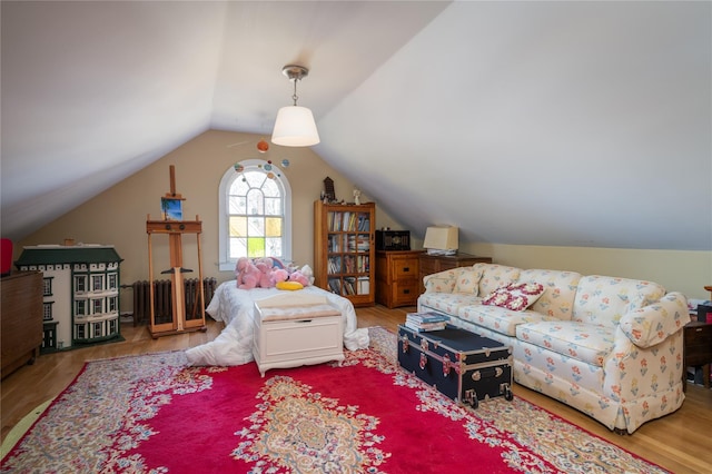 living area with vaulted ceiling and wood finished floors