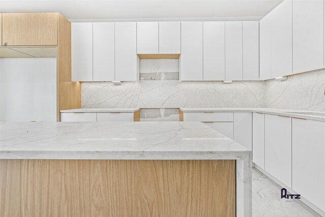 104 Stockton Unit 6, Brooklyn, NY 11206 - kitchen with marble finish floor, modern cabinets, light stone counters, and white cabinets