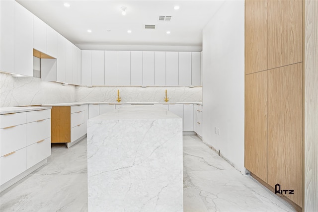 kitchen featuring modern cabinets, a center island, and white cabinets