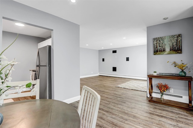 dining room with hardwood / wood-style floors and baseboard heating