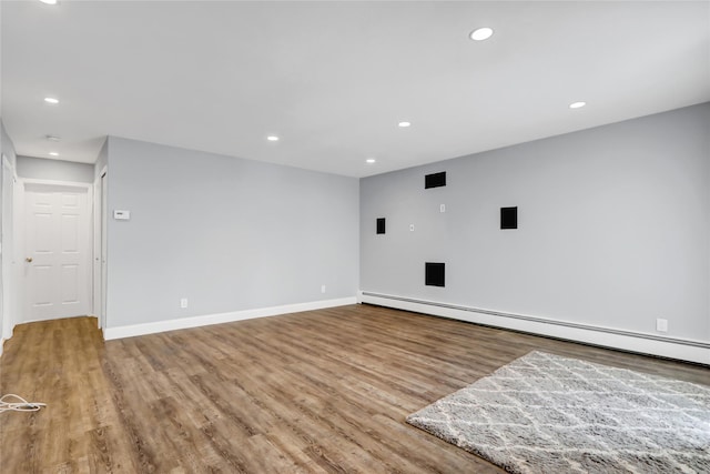 empty room featuring light hardwood / wood-style floors and a baseboard heating unit