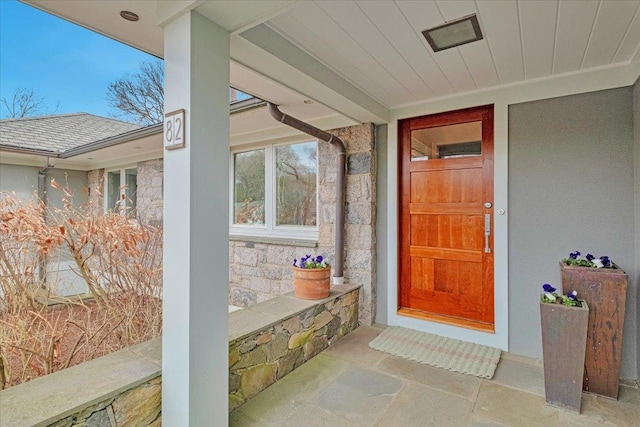 doorway to property with stucco siding and stone siding