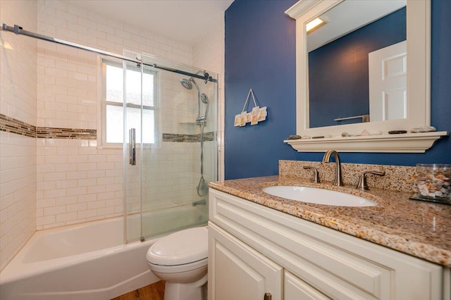 full bathroom with vanity, combined bath / shower with glass door, and toilet