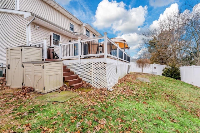 back of property with a storage unit, a yard, and a deck