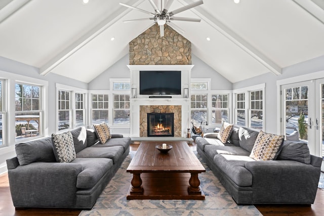 living room with a fireplace, beamed ceiling, hardwood / wood-style flooring, plenty of natural light, and french doors