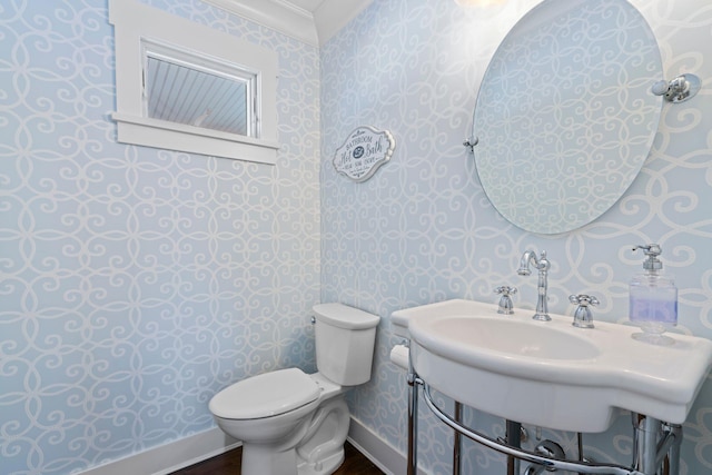 bathroom with ornamental molding and toilet