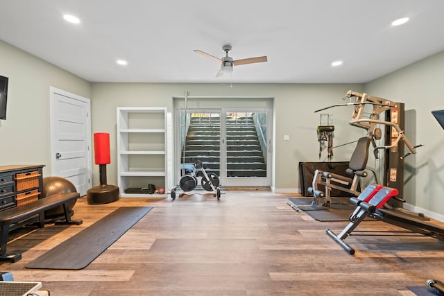 workout area featuring hardwood / wood-style flooring, ceiling fan, and built in shelves