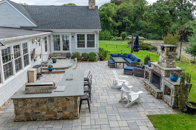 view of patio featuring an outdoor living space with a fireplace and an outdoor kitchen