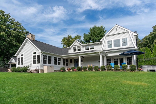 view of front of house featuring a hot tub and a front yard