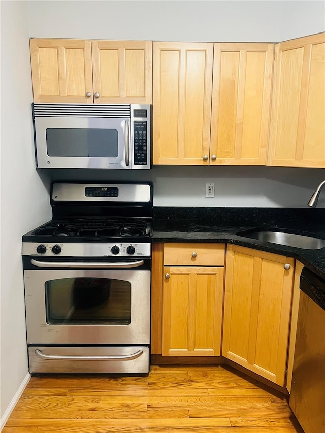 17 Broadway Unit 1K, Harrison, NY 10528 - kitchen with light hardwood / wood-style floors, sink, stainless steel appliances, and dark stone counters