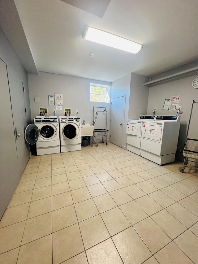 17 Broadway Unit 1K, Harrison, NY 10528 - clothes washing area with light tile patterned flooring, separate washer and dryer, and sink