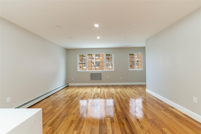 empty room with light wood-type flooring and baseboard heating