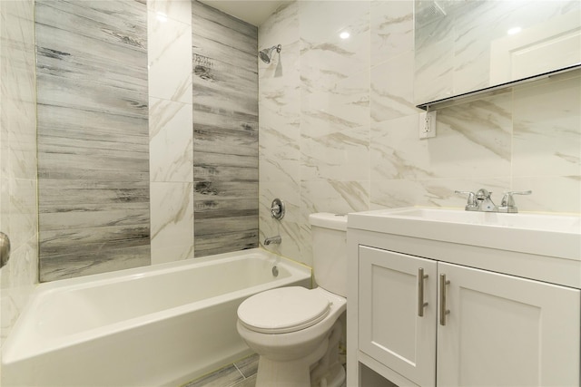 full bathroom featuring tile walls, vanity, tiled shower / bath combo, and toilet