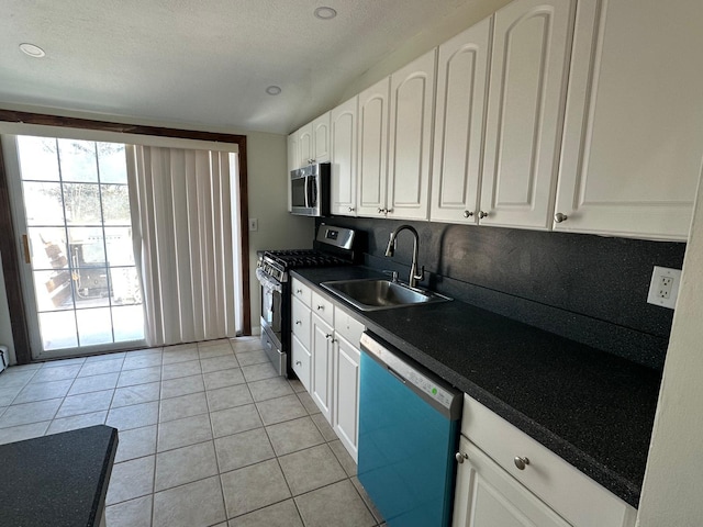 kitchen featuring white cabinetry, appliances with stainless steel finishes, sink, and light tile patterned floors