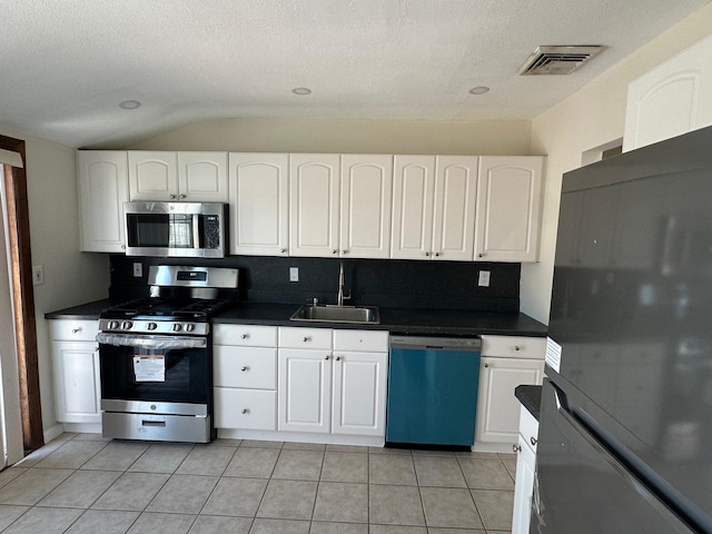 kitchen featuring light tile patterned floors, stainless steel appliances, sink, and white cabinets