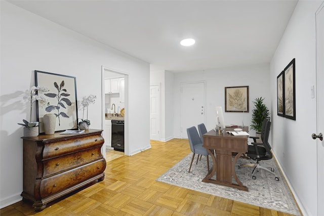 home office featuring light parquet flooring and sink