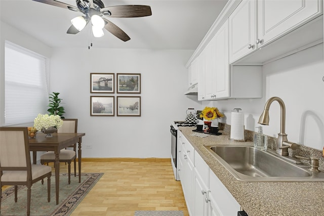 kitchen featuring white cabinetry, white gas range, sink, ceiling fan, and light wood-type flooring