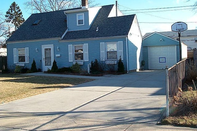 new england style home featuring a garage, an outdoor structure, and a front lawn